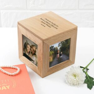 A wooden oak photo cube keepsake box sitting on a white surface, personalised with an engraved message about a mum, with photo panels showing children.