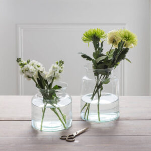 Sustainable and eco-friendly home decor: a set of two recycled glass flower vases, suitable for modern or rustic interior styling.