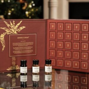 A premium Advent Calendar box featuring 24 individually labelled doors, containing a miniature bottle of spiced rum behind each one. The design is festive and sophisticated, possibly featuring gold foil or deep red coloring. Ideal luxury Christmas gift or adult countdown calendar for rum enthusiasts.