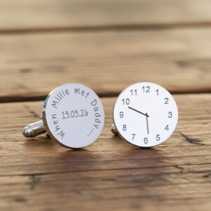 Custom engraved time cufflinks for a new father, a unique baby arrival gift presented on a vintage wooden surface.