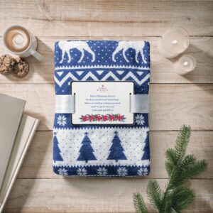 Personalised navy and white reindeer print fleece blanket, folded and tied with a ribbon, featuring a custom card message.