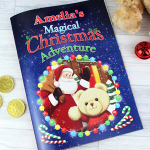 P0512Z41.jpg (Front Cover - Amelia): Close-up of the front cover of 'Amelia's Magical Christmas Adventure Story Book.' It shows Santa Claus and a teddy bear surrounded by festive lights against a dark blue background.