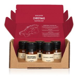 Open Christmas Whisky Tasting Set box showing five 30ml wax-sealed whisky samples inside. The box lid features tasting instructions and a map of Christmas regions like Lapland.