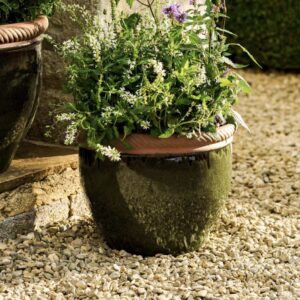 36cm Olive Green ceramic outdoor planter with a glossy finish and twisted terracotta rim, filled with white flowering plants on a gravel patio.