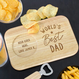 Personalised World's Best Coaster Tray: A rectangular wooden coaster tray on a black surface featuring an engraved "World's Best Dad" design, a circular groove holding a glass of beer, and a handful of crisps on the side, next to a bottle opener.