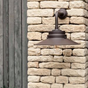 HMS Belfast inspired deck light in Coffee Bean steel mounted on a light stone wall, representing one of four available nautical-inspired colours.