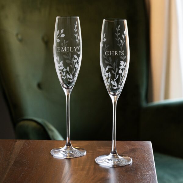 Set of two personalised botanical crystal champagne flutes engraved with names Emily and Chris